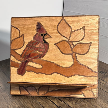 Handmade wood tablet holder with cardinal bird design, crafted from mixed hardwoods, holding iPad on tabletop