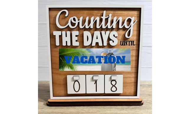 Wooden interchangeable countdown sign displaying “Counting The Days Until” with Vacation plate featuring a beach scene and suitcase, and number tiles showing 018 on a tabletop stand.